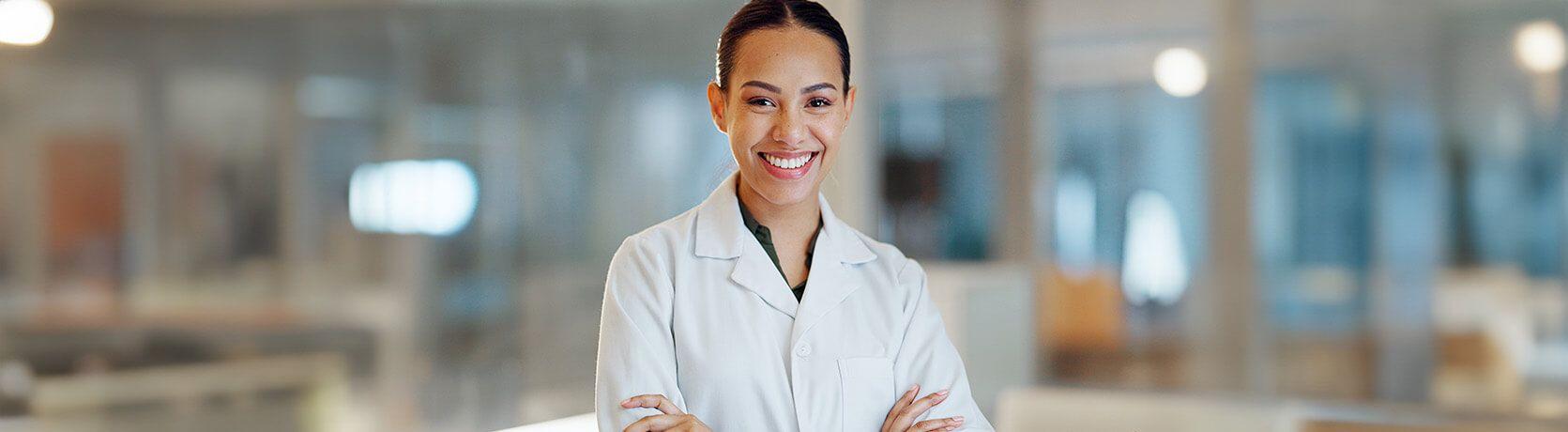 A female healthcare professional smiling and looking into the camera.