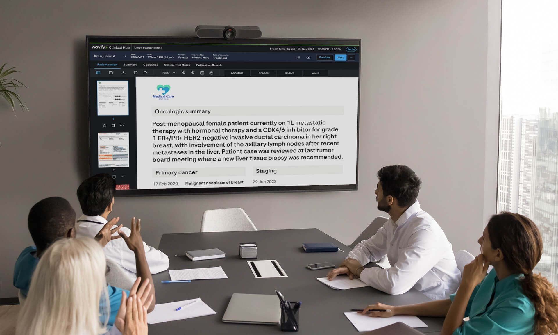 Five healthcare professionals in a meeting watching a presentation on a wall screen.