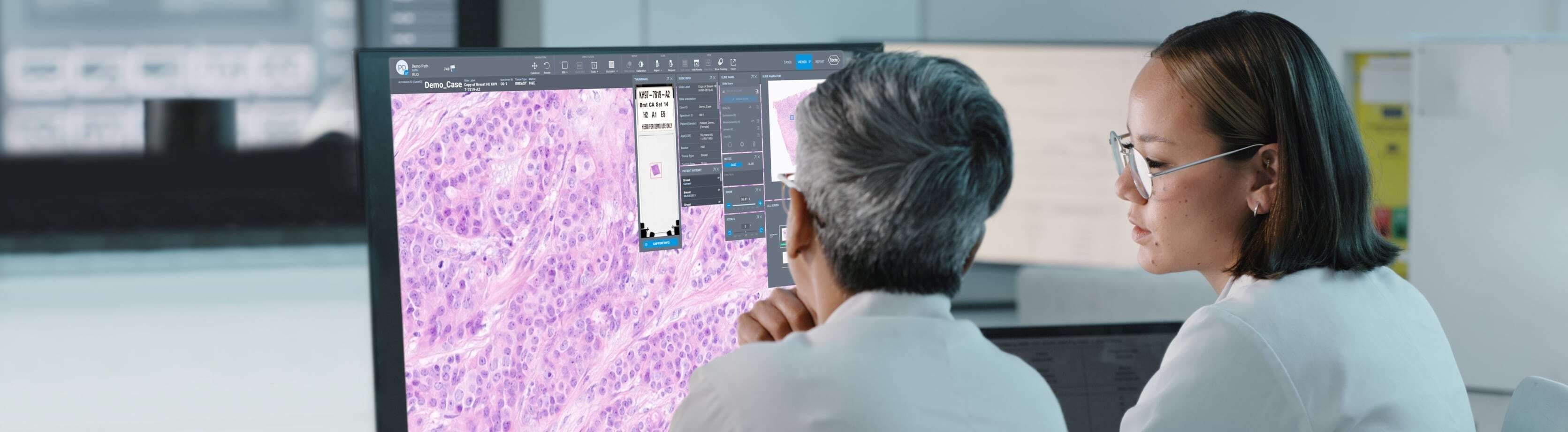Three doctors in a meeting watching a screen on the wall.
