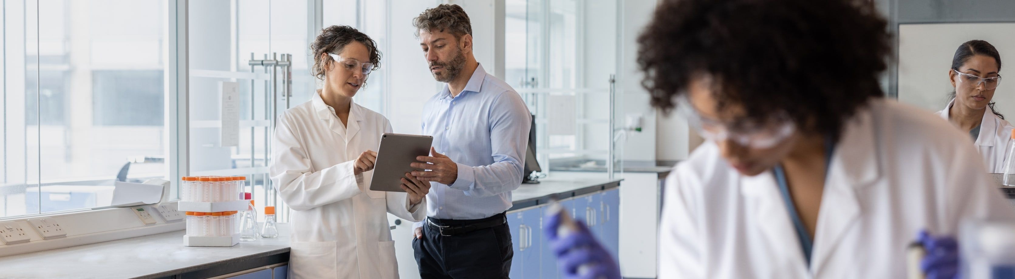 Multiple lab professionals working in a lab environment.