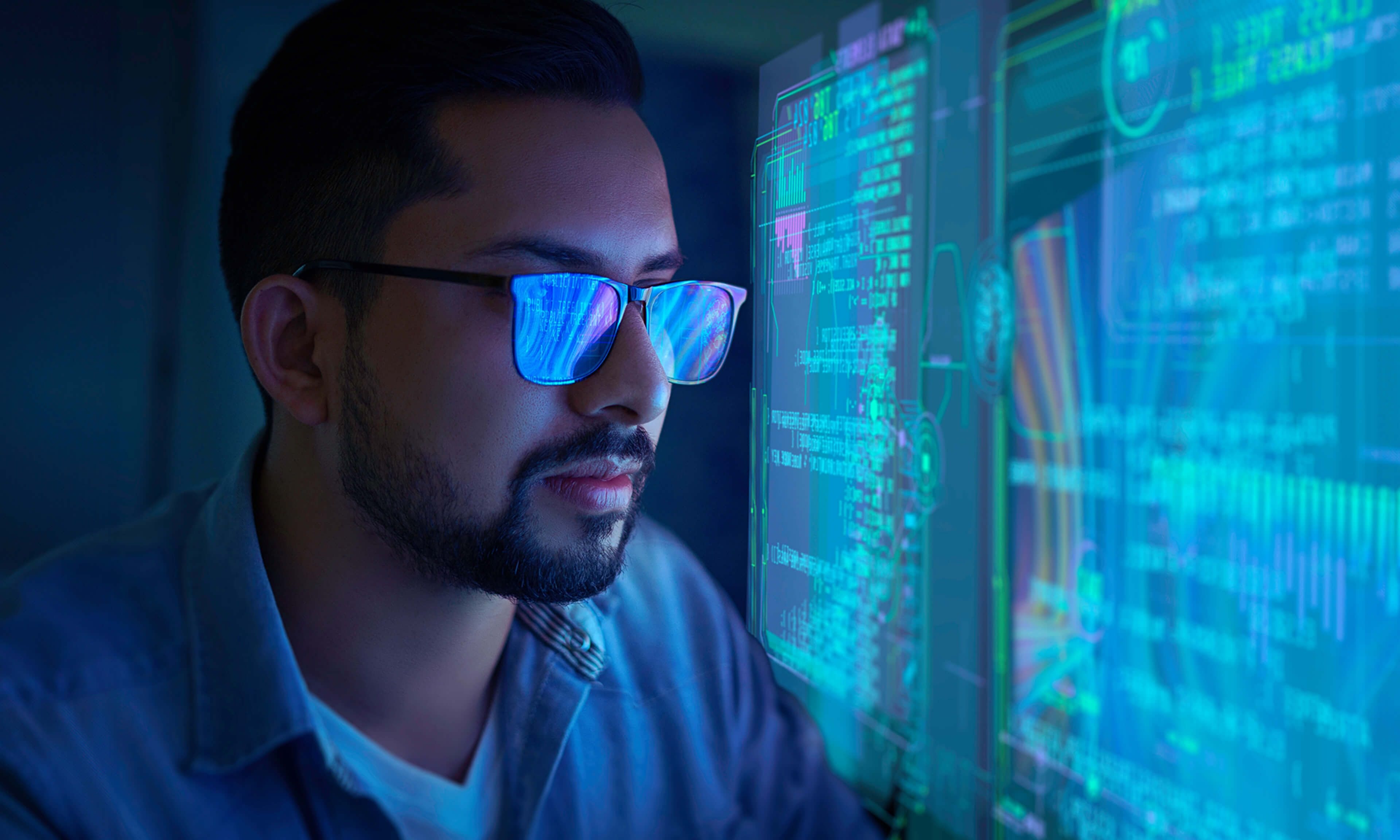 A cybersecurity expert analyzing complex data visualizations on a digital interface, illuminated by glowing blue screens.